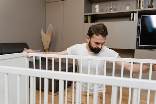 Man setting up a baby crib in a stylish living room, symbolizing preparation for parenthood.